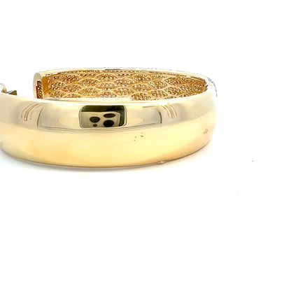 Gold bracelet with intricate design on a white background