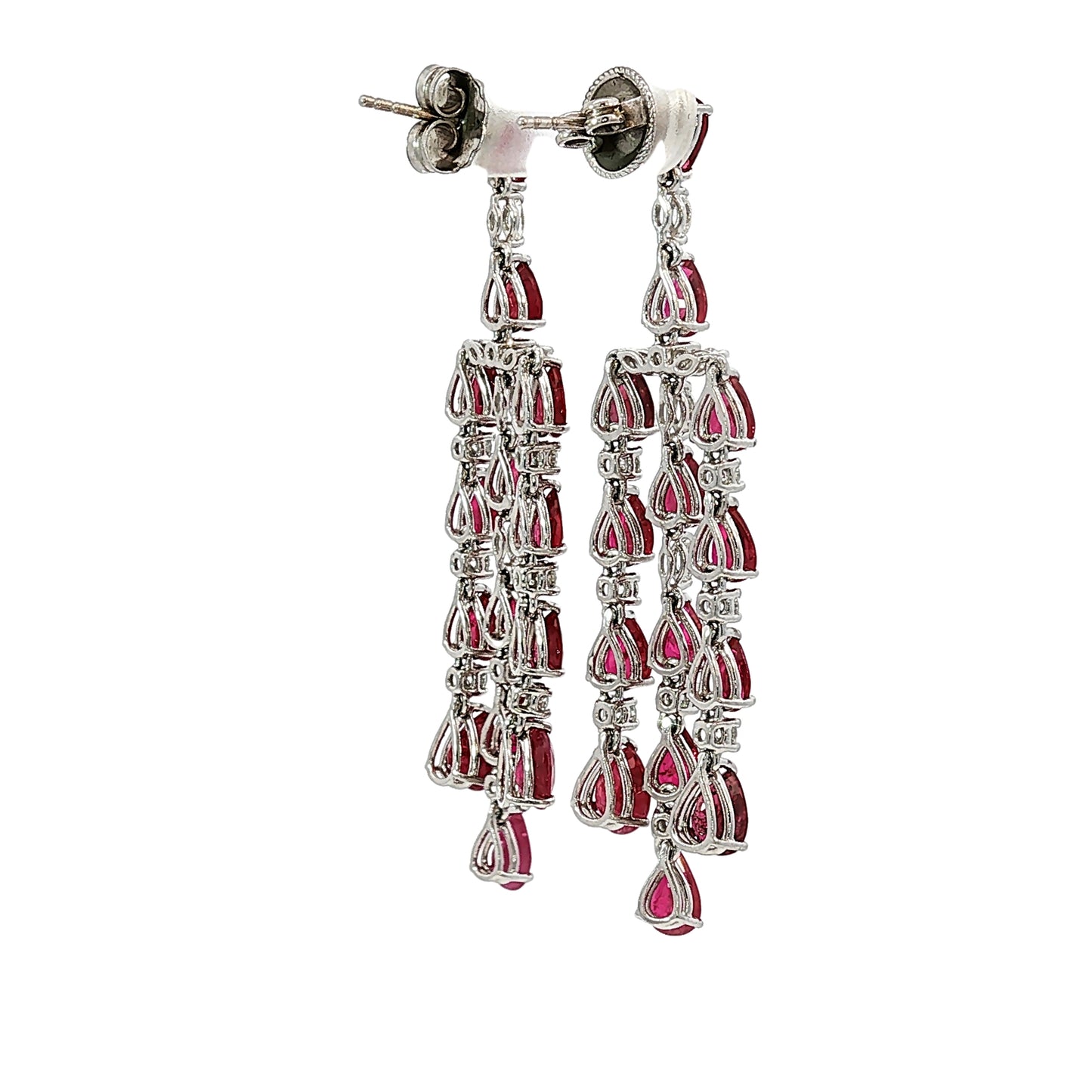 Side profile of 18 karat white gold articulated ruby and diamond chandelier earrings showing open gallery construction and pear-shaped rubies.